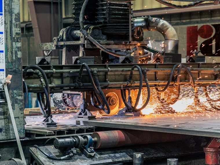Industrial manufacturing machinery on a production line throwing sparks