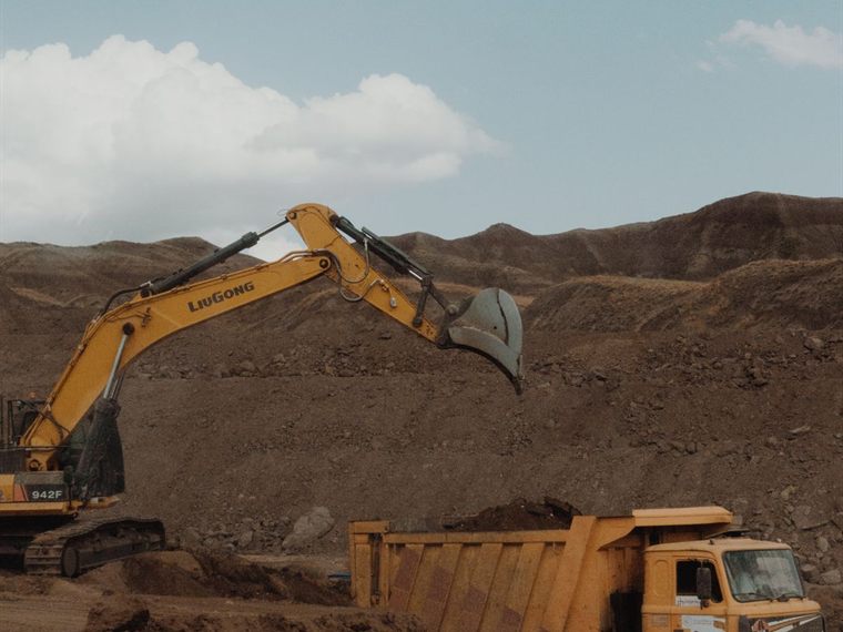 Excavator loading a dump truck at an open-pit mine